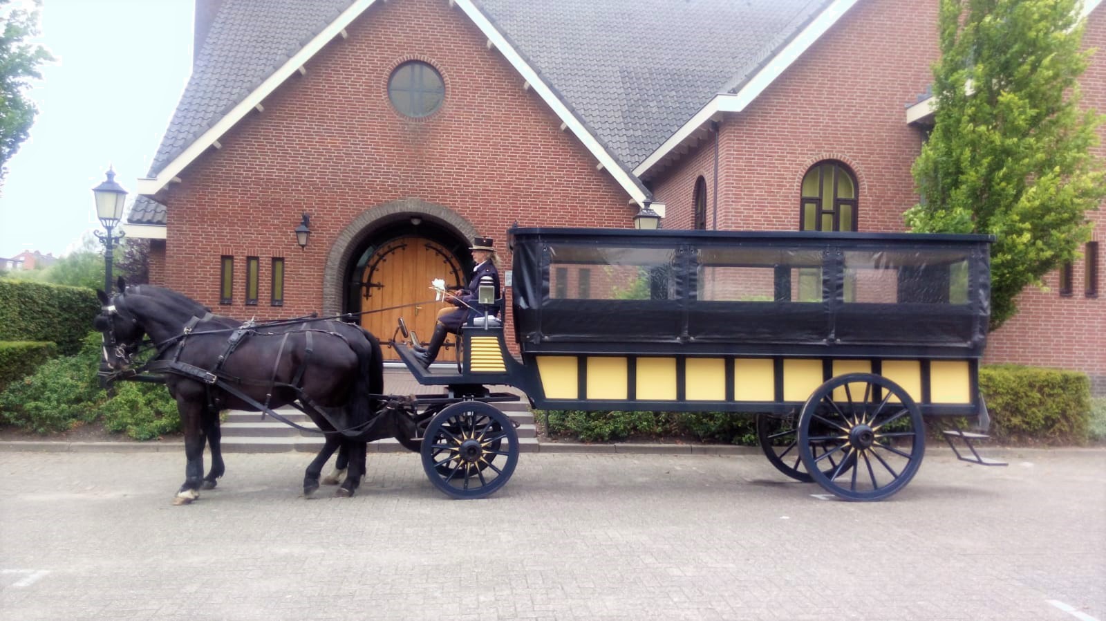 Open houten janplezier met vrolijke gasten en twee zwarte paarden